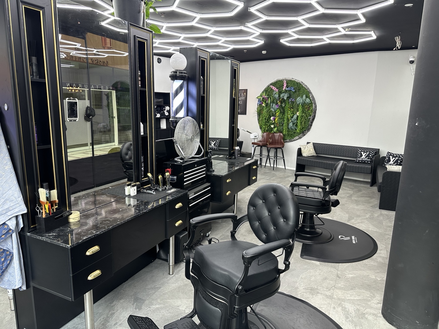 Arbeitsplätze bei MAX Herrenfriseur mit schwarzen Spiegeln und goldenen Details
